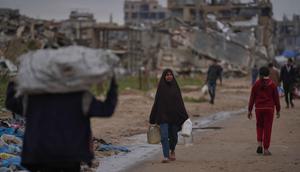 Kondisi infrastruktur sanitasi dan air bersih yang sudah rusak akibat perang, semakin tertekan oleh hujan deras, meningkatkan risiko penyebaran penyakit akibat genangan air limbah dan sampah. Tampak dalam foto, seorang wanita Palestina membawa wadah berisi air di Nuseirat, Jalur Gaza tengah, Jumat, 2 Januari 2026. (AP Photo/Abdel Kareem Hana)