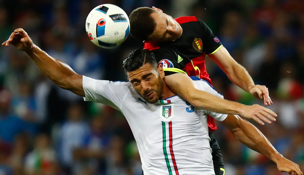 Penyerang Italia, Graziano Pelle (kiri) berebut bola udara dengan bek Belgia, Thomas Vermaelen pada pertandingan grup E Piala Eropa di Stade de Lyon, Prancis, (14/6). Italia menang atas Belgia dengan skor 2-0. (REUTERS/Jason Cairnduff)