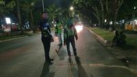 Personel Lalu Lintas Polresta Pekanbaru melakukan olah tempat kerjadian perkara pengemudi ojek online meninggal dunia. (Liputan6.com/M Syukur)