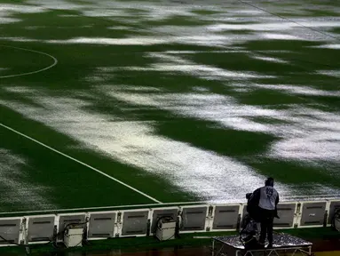 Seorang kamerawan berdiri di pinggir lapangan Stadion Monumental, Buenos Aires, Argentina, yang banjir karena guyuran hujan deras sebelum laga Kualifikasi Piala Dunia 2018 antara Argentina melawan Brasil. Jumat (13/11/2015) WIB. (Reuters/Marcos Brindicci)