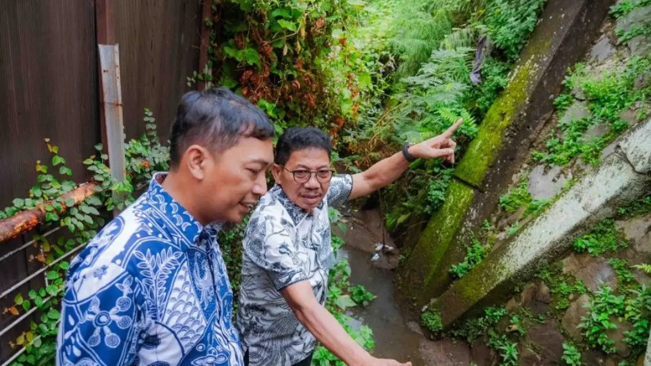 Kepala Dinas PUPR Kota Tangerang Taufik Syahzaeni dan Wali Kota Tangerang Sachrudin berbincang saat mengecek saluran air di pemukiman terkait penanganan banjir.