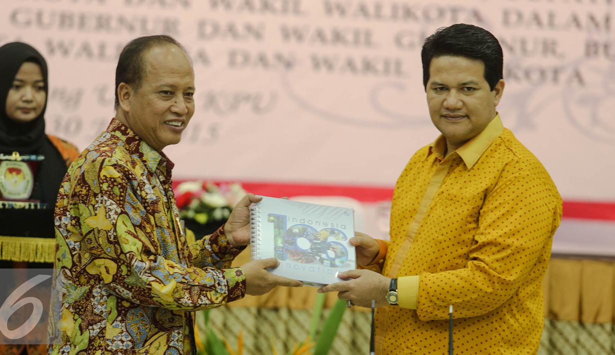 Menristek Dikti, Mohammad Nasir (kiri) bertukar cinderamata dengan Ketua KPU, Husni Kamil di Kantor KPU, Jakarta, Kamis (30/7/2015). Penandatangan terkait kerjasama verifikasi ijazah dalam rangka Pilkada serentak. (Liputan6.com/Faizal Fanani)