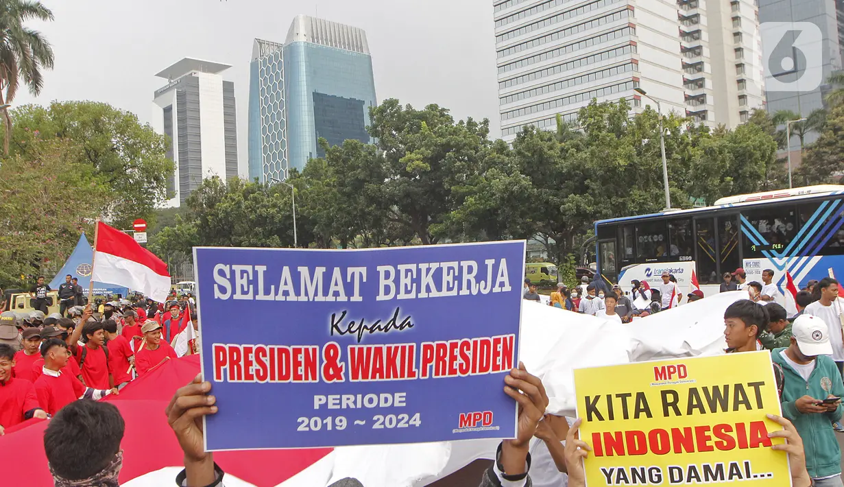 Massa yang tergabung dalam Masyarakat Penegak Demokrasi (MPD) menggelar aksi damai "Menyambut Pelantikan Presiden dan Wapres RI Terpilih" di Kawasan Patung Kuda, Jakarta, Kamis (10/10). Mereka mengimbau masyarakat menjaga situasi aman dan damai jangan terprovokasi. (Liputan6.com/Herman Zakharia)