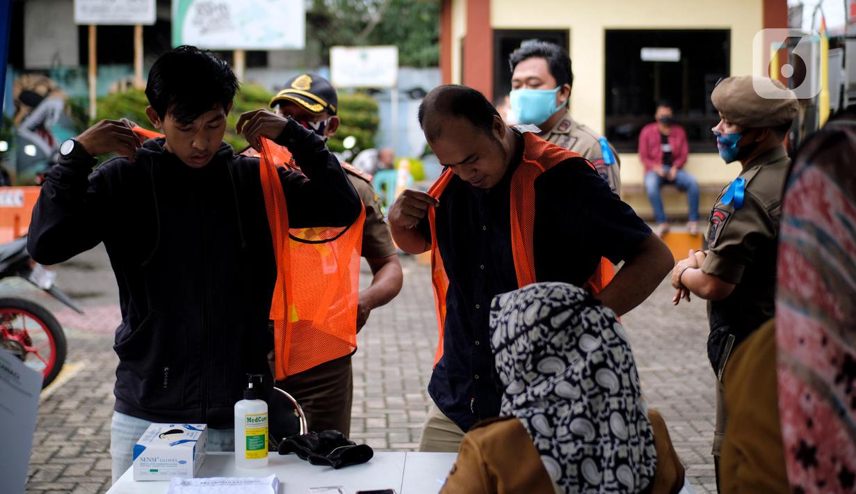 Petugas menghukum warga yang tidak mengenakan masker di Kelurahan Cimone, Kota Tangerang, Banten, Rabu (15/7/2020). Guna memberi efek jera, Pemkot Tangerang memberlakukan sanksi sosial kepada pelanggar PSBB seperti menyapu dengan memakai rompi bertulis ‘Pelanggar PSBB’. (Liputan6.com/Angga Yuniar)