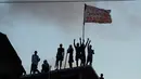 Para tahanan mengibarkan bendera diatas atap usai bentrokan antar dua geng narkoba di penjara Alcacuz, Rio Grande do Norte, Brasil, (16/1). Sebagian besar jenazah ditemukan dalam kondisi termutilasi. (AFP Photo/Andressa Anholette)