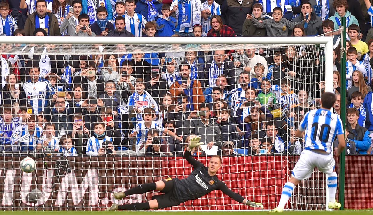 Striker Real Sociedad, Mikel Oyarzabal, mencetak gol ke gawang Barcelona pada laga La Liga di Stadion Anoeta, San Sebastian, Sabtu (14/12). Kedua klub bermain imbang 2-2. (AFP/Ander Gillenea)