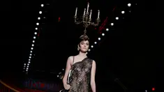 Model mengenakan busana rancangan Moschino dengan hiasan kepala berbentuk tempat lilin dalam Milan Fashion Week Autumn/Winter 2017 di Milan, Italia, (23/2). (AFP Photo / Marco Bertorello)