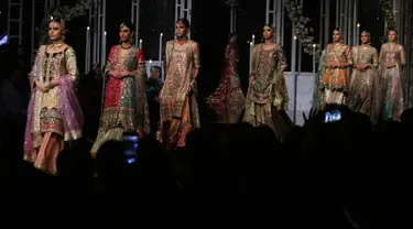 Model membawakan busana rancangan desainer Annus Abrar  selama Bridal Couture Week di Lahore, Minggu (9/12). Para model cantik memperagakan kreasi gaun pengantin dari sejumlah desainer ternama di Pakistan. (AP Photo/K.M. Chaudary)