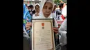 Salah satu keluarga veteran  membawa piagam bintang gerilya saat melakukan unjuk rasa di depan Gedung KPK, Jakarta, Kamis (18/12/2014). (Liputan6.com/Miftahul Hayat)