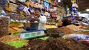 Pedagang buah dan kacang kering menimbang segenggam almond di sebuah toko di Sanaa, Yaman, Rabu (20/5/2020). Umat muslim seluruh dunia bersiap menyambut Idul Fitri yang sekaligus menandai berakhirnya bulan suci Ramadan. (Mohammed HUWAIS/AFP)