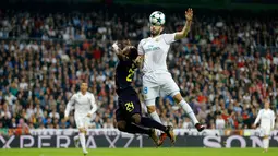 Pemain Real Madrid, Karim Benzema melompat untuk merebut bola dari pemain Tottenham Hotspur Serge Aurier pada laga lanjutan fase Grup H Liga Champions di Santiago Bernabeu, Selasa (17/10). Madrid ditahan imbang tamunya Tottenham 1-1.  (AP/Francisco Seco)