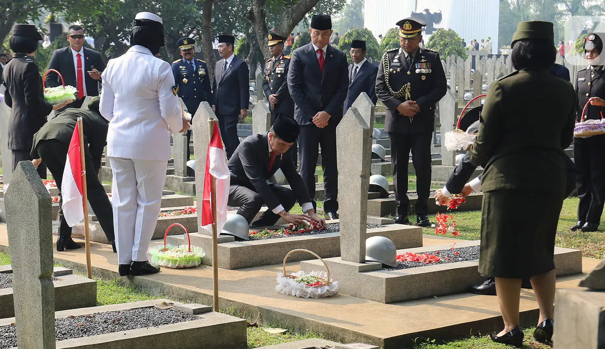 Presiden Joko Widodo melakukan tabur bunga usai Upacara Peringatan Hari Pahlawan Nasional di Taman Makam Pahlawan (TMP) Utama Kalibata, Jakarta Selatan, Minggu (10/11/2019). Tabur bunga dilaksanakan sebagai bentuk penghormatan terhadap jasa pahlawan. (Liputan6.com/Herman Zakharia)