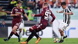 Striker Juventus, Paulo Dybala, berusaha melewati pemain Torino pada laga Serie A, Italia, di Stadion Allianz, Sabtu (23/9/2017). Juventus menang 4-0 atas Torino. (AFP/Filippo Monteforte)