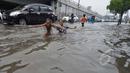 Suasana arus lalu lintas di Jalan Pramuka, Jakarta, yang tergenang banjir hingga mencapai 20 cm, Minggu (1/2/2015). (Liputan6.com/Andrian M Tunay)