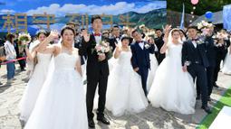 Para pasangan yang bergabung dalam perjuangan melawan COVID-19 mengikuti nikah massal di Provinsi Jilin, China, Rabu (8/7/2020). Nikah massal ini dihelat untuk 50 pasangan dari seluruh China yang telah berjuang melawan COVID-19 dan menunda pernikahan mereka. (Xinhua/Lin Hong)