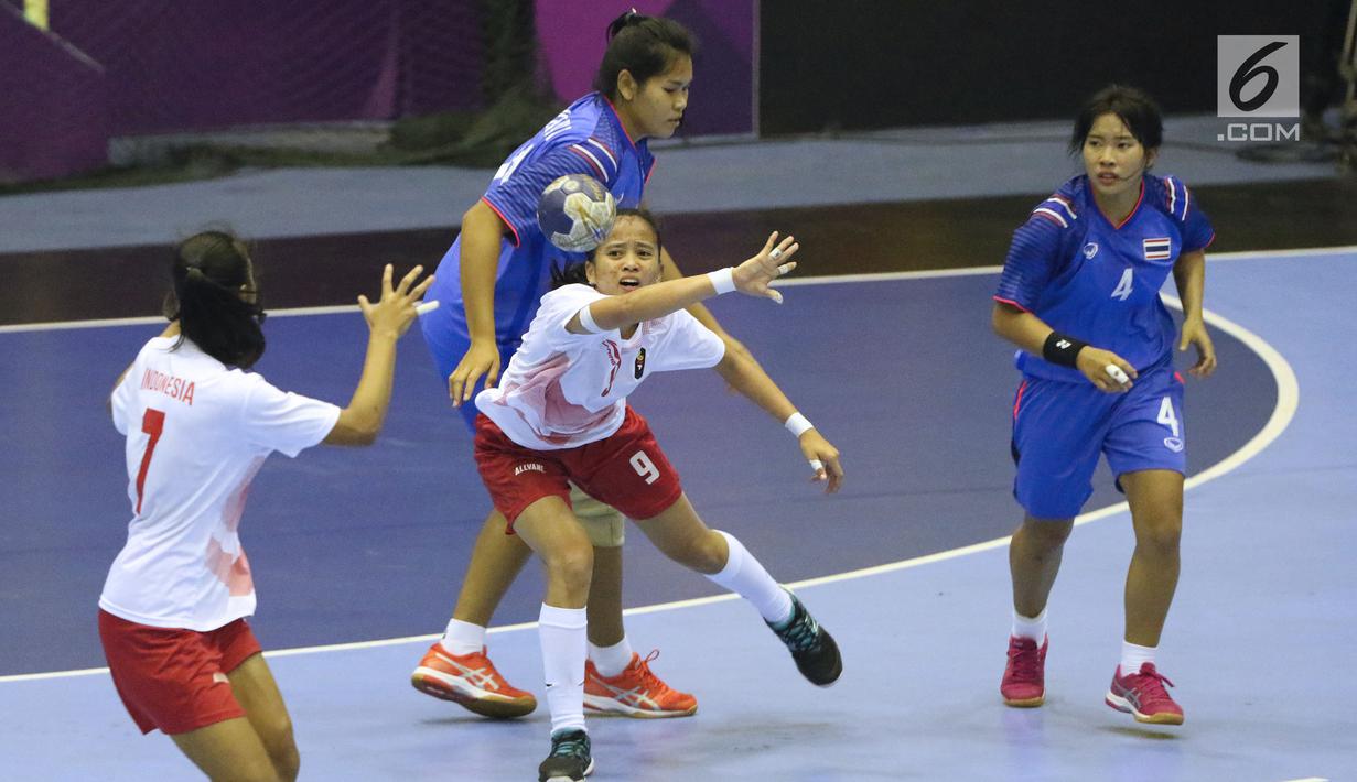 Pemain bola tangan putri Indonesia, Lia Apriliani (tengah) mencoba mengatur serangan saat melawan Thailand pada babak penyisihan grup B Asian Games 2018 di Jakarta, Kamis (16/8). Indonesia kalah 16-34. (Liputan6.com/Helmi Fithriansyah)