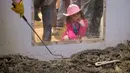 Seorang gadis muda mengintip ke kandang ular derik dalam kompetisi Roundup Rattlesnake Sweetwater di Texas, Amerika Serikat, Sabtu (10/3). Kompetisi tahunan ini dimulai dengan berburu ular derik. (Loren Elliott/AFP)