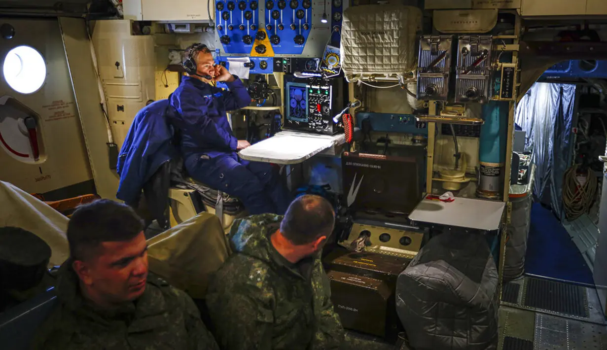 Seorang awak pesawat kargo militer Rusia Il-76 (depan) bekerja selama penerbangan ke Pulau Alexandra Land di Kepulauan Franz Josef Land, Rusia, Senin (17/5/2021). Pulau Alexandra Land merupakan pangkalan militer paling utara Rusia. (AP Photo/Alexander Zemlianichenko)
