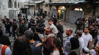 Pasukan Israel menutup paksa kompleks Masjid Al-Aqsa di Kota Tua Yerusalem, Jumat (17/8). Menurut media lokal Palestina, jemaah dipaksa keluar dari kompleks oleh polisi dan tentara Israel, yang kemudian menutup gerbang ke Kota Tua. (AFP/Ahmad GHARABLI)