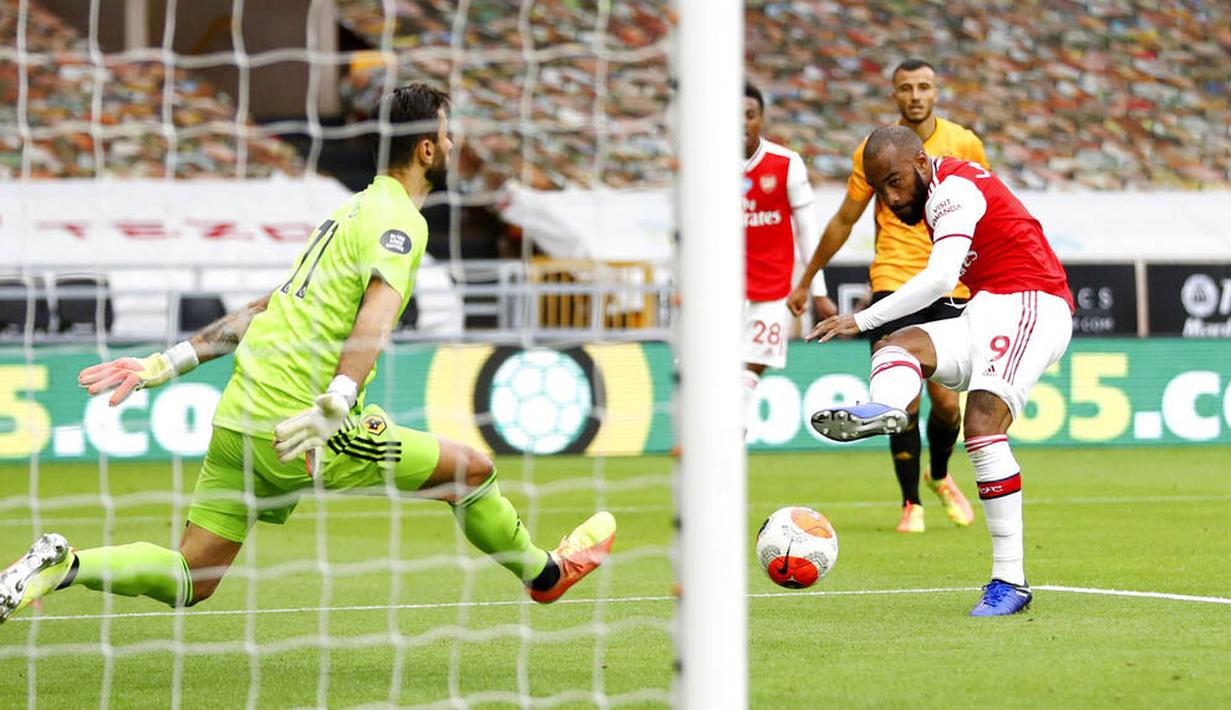 Striker Arsenal, Alexandre Lacazette, mencetak gol ke gawang Wolverhampton Wanderers pada laga Premier League di Stadion Molineux, Sabtu (4/6/2020). Arsenal menang dengan skor 2-0. (AP/Michael Steele)
