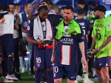 Ekspresi pemain Paris Saint-Germain, Lionel Messi, terlihat tidak begitu menikmati pesta juara yang digelar klubnya saat menjuarai Liga Prancis 2022/2023 di Parc des Princes Stadium, Minggu (4/6/2023) dini hari WIB. (AFP/Franck Fife)