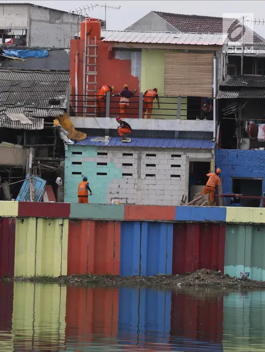Petugas Penanganan Prasarana dan Sarana Umum (PPSU) mengecat rumah warga yang berada di pinggir Danau Sunter Jakarta, Kamis (22/3). (Liputan6.com/Arya Manggala)