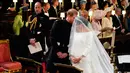 Pangeran Harry berbicara kepada Meghan Markle saat prosesi pernikahan mereka di Kapel St. George, Kastil Windsor, Inggris, Sabtu (19/5). Pangeran Harry dan Meghan Markle resmi menjadi suami istri. (Gareth Fuller/pool photo via AP)
