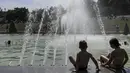 Anak-anak bermain air mancur di kolam di Trocadero Fountains dekat Menara Eiffel, Paris (22/7/2019). Warga Paris bersiap menghadapi suhu terpanas pada minggu ini ketika gelombang panas akan melanda ke Eropa utara. (AFP Photo/Alain Jocard)