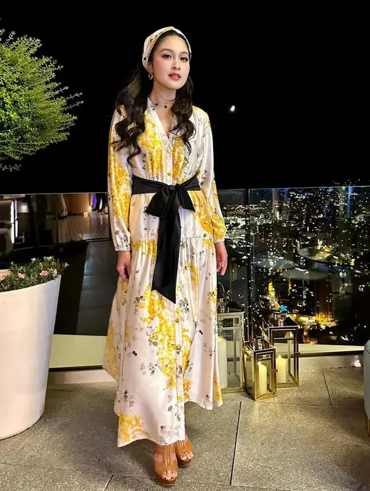 Saat makan malam bersama sang suami, wanita yang begitu mencintai kisah Disney ini tampil lebih segar dengan simpel dres berwarna putih serta corak bunga kuning. Penampilannya ini juga ia tambahkan ikat pinggang pita berwarna hitam. (Liputan6.com/IG/@sandradewi88)
