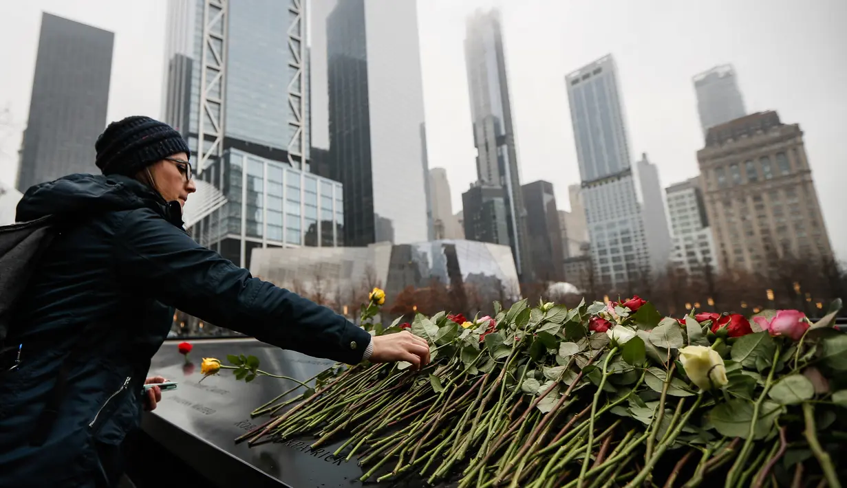 Orang-orang menaruh bunga mawar di atas nama korban pengeboman World Trade Center 1993 pada upacara peringatan “Tragedi 9/11” di New York, Rabu (26/2/2020). 27 tahun lalu teroris meledakkan bom di sebuah garasi parkir World Trade Center (WTC) yang menewaskan enam korban. (AP/John Minchillo)