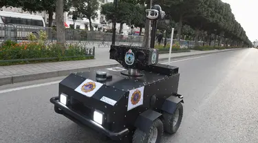 Robot polisi Tunisia berpatroli selama kebijakan penguncian (lockdown) di sepanjang Avenue Habib Bourguiba, pusat ibu kota Tunis, Rabu (1/4/2020). Robot itu dikendalikan dari jarak jauh untuk berkeliling dan membagikan sanksi terhadap warga yang melanggar aturan karantina. (FETHI BELAID/AFP)