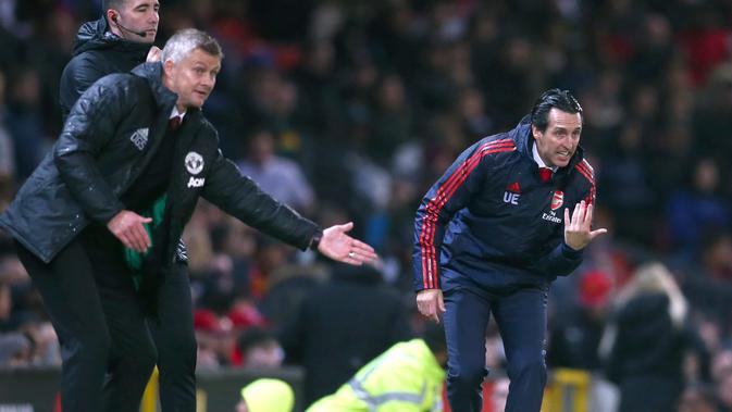 Pelatih Kepala Arsenal Unai Emery (kanan) dan Manajer Manchester United Ole Gunnar Solskjaer (kiri) memberikan instruksi kepada anak asuhnya dari luar lapangan saat bertanding dalam lanjutan Liga Inggris di Old Trafford, Manchester, Inggris, Senin (30/9/2019). (AP Photo/Dave Thompson)