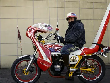 Seorang pemilik motor lama Bousouzoku saat sedang berhenti di daerah Yamanashi, Jepang , (3/1). Mesikpun motor tahun 1950-an ini ilegal berkendara di Jepang tetapi puluhan pengemudi motor ini tetap melakukan touring. (REUTERS / Thomas Peter)