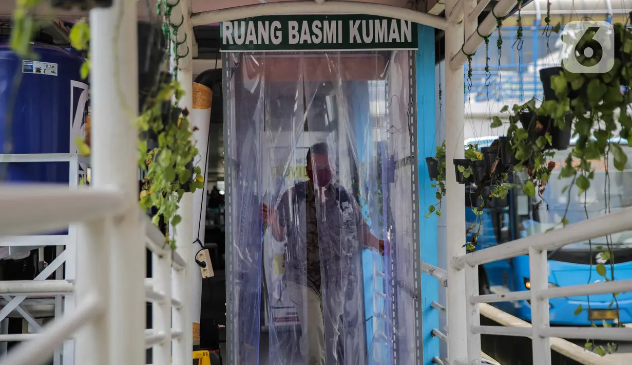 Calon penumpang memasuki bilik disinfektan di Halte Transjakarta Harmoni, Jakarta, Selasa (7/4/2020). Pemasangan bilik disinfektan tersebut sebagai upaya pencegahan penyebaran virus Corona COVID-19 di lingkungan Halte Transjakarta. (Liputan6.com/Faizal Fanani)
