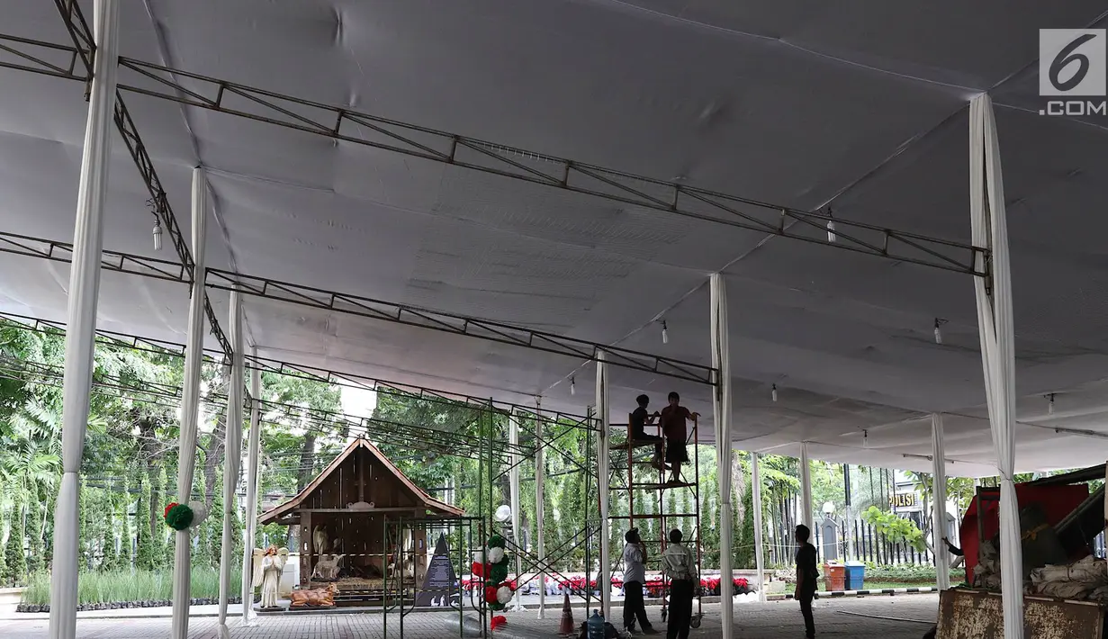 Pekerja menyelesaikan pembuatan tenda dan dekorasi Natal di Gereja Katedral, Jakarta, Kamis (20/12). Pendirian tenda dilakukan untuk melayani umat yang biasanya membeludak saat pelaksanaan Misa Natal. (Liputan6.com/Immanuel Antonius)