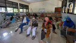 Warga menunggu vaksinasi COVID-19 petugas kesehatan dari Puskesmas Kecamatan Matraman di SD Negeri 25 Utan Kayu Selatan, Matraman, Jakarta Timur, Rabu (23/3/2022). Layanan vaksinasi digelar setiap hari Senin sampai Jumat pukul 08.00-11.00 WIB. (Liputan6.com/Herman Zakharia)