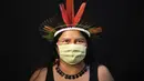 Dilza (39) dari kelompok etnis pribumi Sateré Mawé mengenakan pakaian tradisional sukunya dan masker saat pandemi virus corona COVID-19 di Manaus, Brasil, Rabu (27/5/2020). (AP Photo/Felipe Dana)