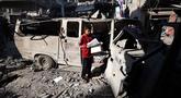 Seorang anak pengungsi Palestina berdiri di dekat bangunan yang rusak akibat serangan Israel di kamp pengungsi Maghazi, Jalur Gaza Tengah pada Kamis 21 Mei 2026. (Eyad Baba/AFP)