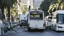 Seorang petugas kepolisian saat memeriksa keadaan bis yang hancur pasca serangan bom di Tunisia, (25/11).  Peristiwa pemboman ini menewaskan sedikitnya 13 orang. (REUTERS/Zoubeir Souissi)