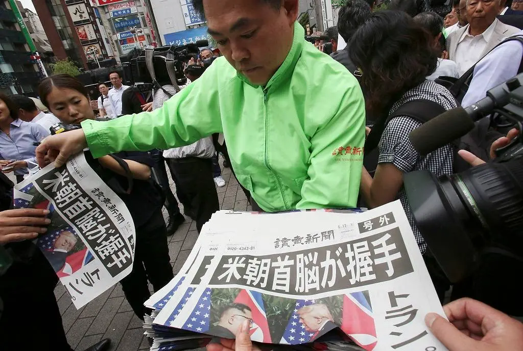 Koran edisi khusus yang memberitakan pertemuan bersejarah Donald Trump dan Kim Jong-un di Singapura. (Photo: AFP/Kazuhiro Nogi)