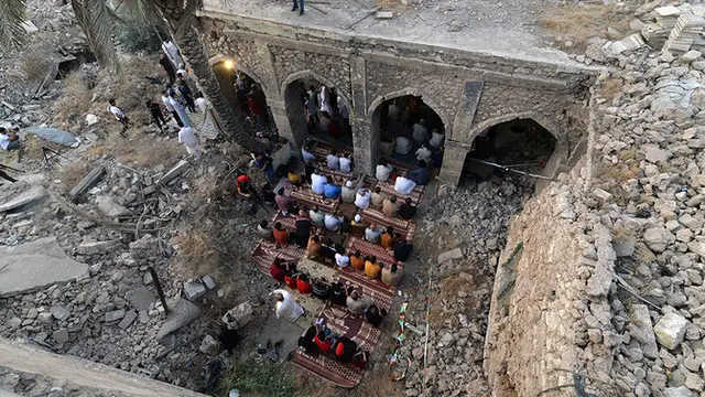 Jamaah Irak mengambil bagian dalam salat Idul Fitri pada Kamis (13/5) di halaman masjid Umayad yang rusak di Kota Tua Mosul. (AFP)