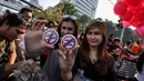 Sejumlah perempuan cantik menunjukkan pin bertuliskan "peninjauan kembali status Budi Gunawan" saat menggelar aksi di Bundaran HI, Minggu (4/4/2015). Padahal, Pemprov DKI melarang adanya kegiatan bernuansa politik saat CFD. (Liputan6.com/Faizal Fanani)