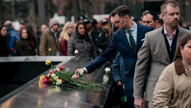 Kerabat dan pelayat meletakkan mawar di atas plakat bertuliskan nama-nama korban pengeboman World Trade Center 1993 pada upacara peringatan di New York, Rabu (26/2/2020). 27 tahun lalu teroris meledakkan bom di sebuah garasi parkir WTC yang menewaskan enam korban. (Scott Heins/Getty Images/AFP)