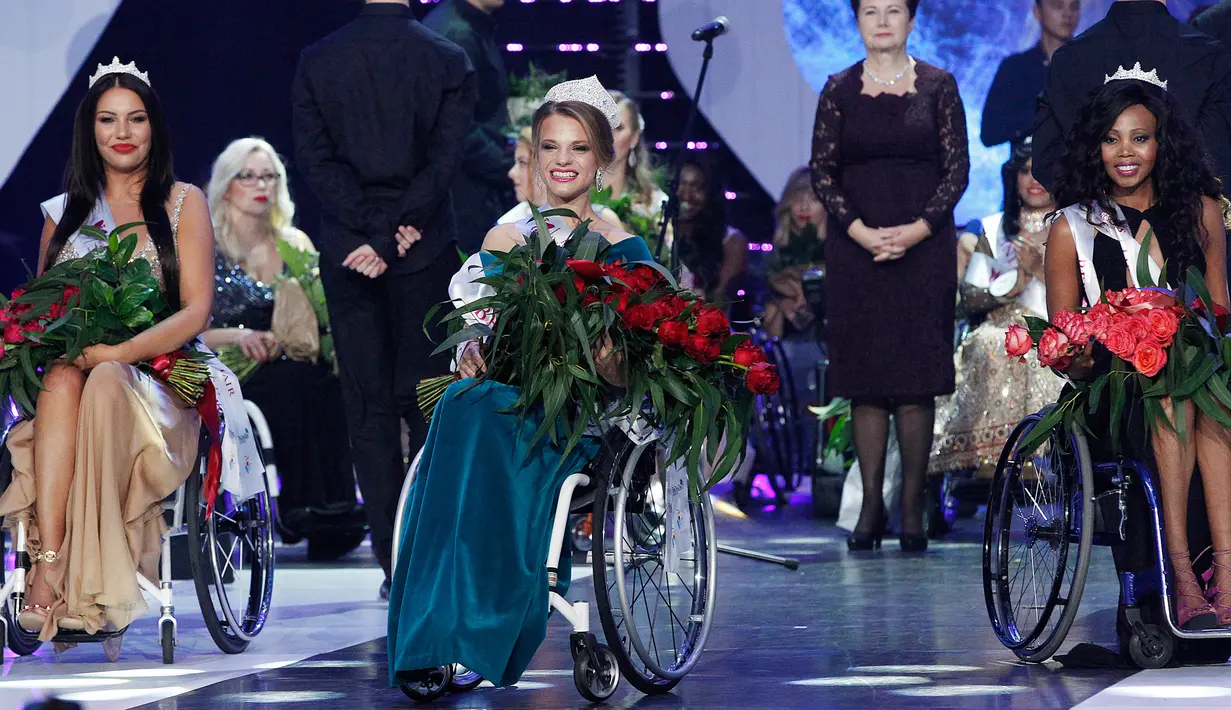 Miss Belarus Aleksandra Chichikova (tengah) terpilih sebagai Miss Wheelchair World di Warsawa, Polandia, Sabtu (7/10). Di ajang tersebuti, kontestan saling berbagi pengalaman pribadi, termasuk tantangan saat menggunakan kursi roda.  (AP/Czarek Sokolowski)