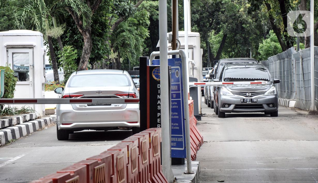 Mobil pengunjung melintasi pintu parkir IRTI Monas, Jakarta, Rabu (15/2/2023). Mobil yang telah lolos uji emisi akan dikenakan tarif parkir sebesar Rp 4.000 per jam, sedangkan yang belum lolos dikenakan tarif sebesar Rp 7.500. (merdeka.com/Iqbal S. Nugroho)