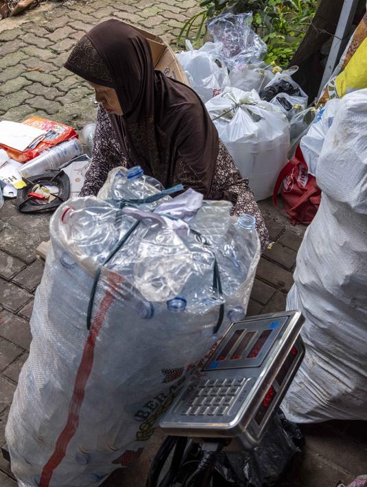 Seorang pegawai bank sampah menimbang sampah rumah tangga anorganik, berupa kardus dan botol plastik, Jakarta, Kamis 4 Juni 2026, sebagai bagian dari instruksi Pemprov DKI yang mewajibkan warga memilih dan memilah sampah untuk mengurangi beban sampah yang semakin menumpuk di ibu kota. (BAY ISMOYO/AFP)