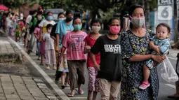 Warga menerapkan jaga jarak aman saat antre untuk mendapatkan takjil di Jalan Cempaka Putih Raya, Jakarta, Senin (11/5/2020). Setiap hari selama Ramadan, masyarakat sekitar membagikan 350 takjil kepada warga kurang mampu dan terdampak virus corona COVID-19. (Liputan6.com/Johan Tallo)