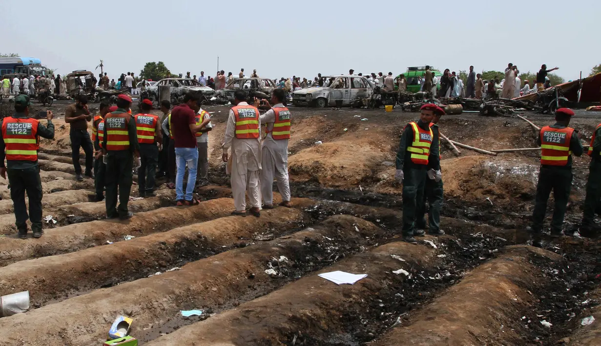Petugas penyelamat Pakistan mengevakuasi lokasi ledakan truk tangki minyak di jalan raya dekat Bahawalpur, Pakistan (25/6). Korban tewas mayoritas mereka yang awalnya mencoba mengumpulkan bahan bakar yang tercecer dari truk tangki. (AP Photo / Iram Asim)