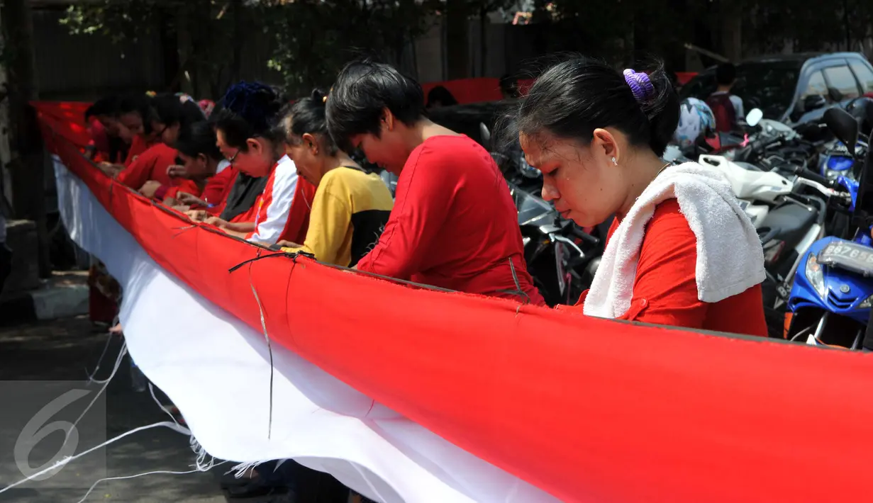 Sejumlah warga tampak serius menjahit bendera merah putih saat mengikuti lomba di Kelurahan Pekojan, Jakarta, Minggu (16/8/2015). Sebanyak 700 ibu-ibu mengikuti lomba menjahit bendera Merah Putih sepanjang 500 meter. (Liputan6.com/Panji Diksana)