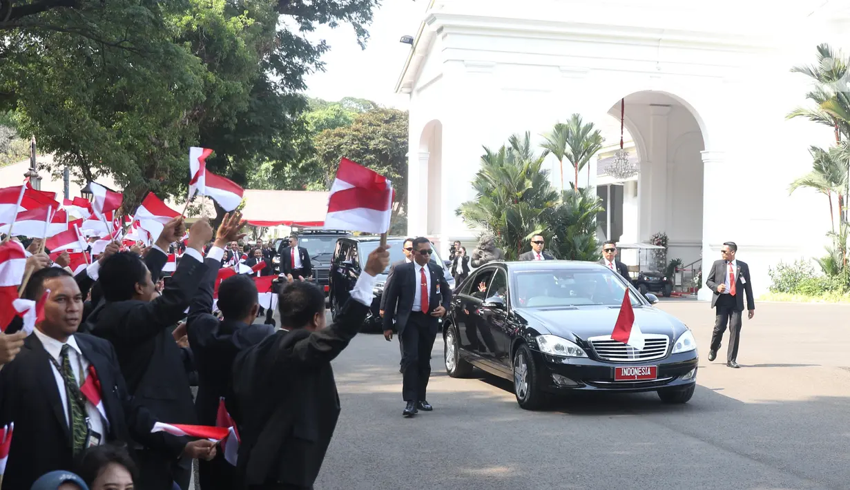 Pegawai Istana mengibarkan bendera merah putih saat rombongan mobil Presiden terpilih Joko Widodo (Jokowi)  melintas menuju gedung DPR di Istana Kepresidenan, Jakarta, Minggu (20/10/2019). Jokowi-Ma'ruf Amin kembali dilantik sebagai Presiden-Wapres RI periode 2019-2024. (Liputan6.com/Angga Yuniar)
